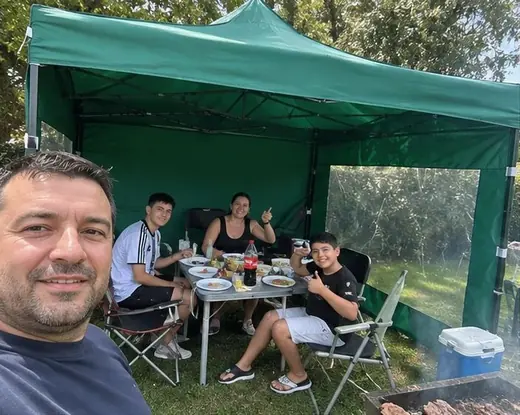 Familia almorzando bajo un gazebo verde