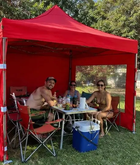 Amigos comiendo bajo un gazebo rojo