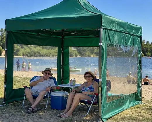 Pareja junto al lago bajo un gazebo verde