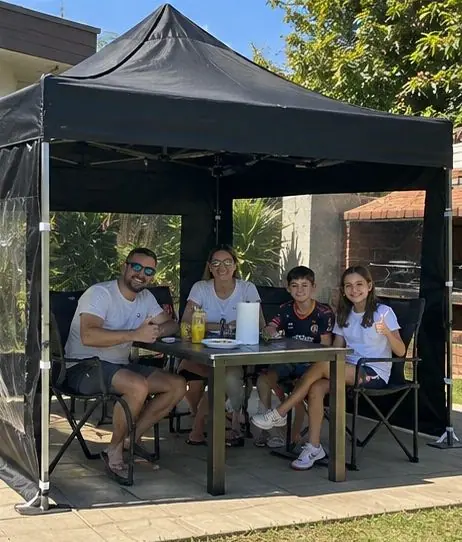 Familia comiendo bajo un gazebo negro